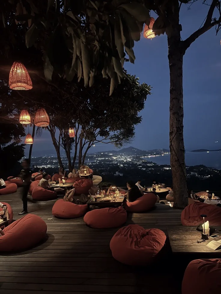 A hilltop terrace overlooking the island lights at night